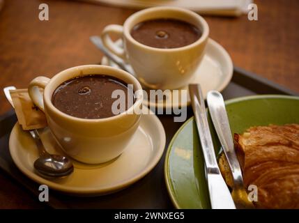 Alcuni visitatori bevono cioccolato nel negozio Xocolates Pirineus, a Puigcerdà (Cerdanya, Girona, Catalogna, Spagna) Foto Stock