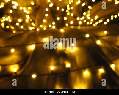 Bellissime ghirlande decorano il centro della città. Decorazioni di strada per Capodanno e buon Natale. Illuminando numerose lampadine gialle e bianche al buio Foto Stock