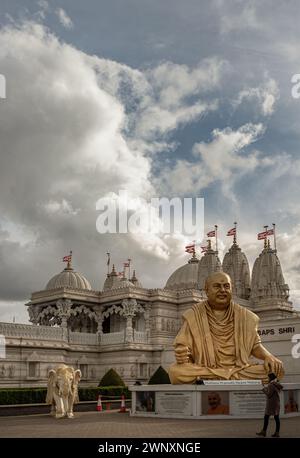 Londra, Regno Unito - 23 febbraio 2024 - Vista esterna del tempio Neasden (BAPS Shri Swaminarayan Mandir) e la statua color oro raffigura il tardo spirituale Foto Stock