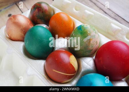 Le uova di Pasqua colorate si chiudono in una confezione di plastica. Dieci colorate uova natalizie sono impilate l'una vicino all'altra. Uova di pollo bollite con fiori e. Foto Stock