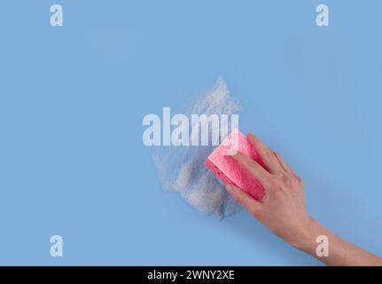 Donna che tiene la spugna di lavaggio mano e detersivo suta Foto Stock