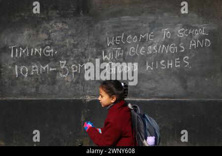 Srinagar, India. 4 marzo 2024. 4 marzo 2024, Srinagar, India: Un bambino passa davanti a una lavagna scritta durante il primo giorno di lezioni dopo la ripresa delle attività scolastiche che sono state interrotte dal forte inverno. Gli studenti attraverso la valle si dirigono verso le loro scuole dopo una pausa invernale di due mesi. Il 4 marzo 2024 a Srinagar Kashmir, India. (Foto di Firdous Nazir/Eyepix Group) credito: SIPA USA/Alamy Live News Foto Stock