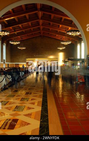 I viaggiatori corrono attraverso l'ingresso ad arco della Union Station di Los Angeles Foto Stock