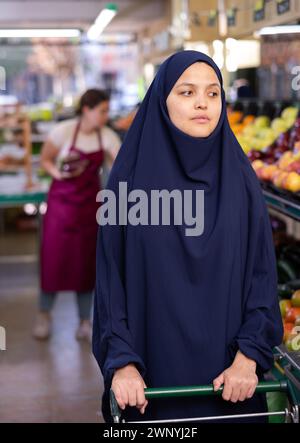 Ritratto di giovane donna acquirente in hijab in supermercato Foto Stock