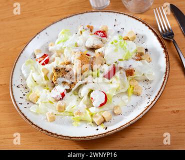 Variante di Caesar Salad con pollo, mix di lattuga e cracker Foto Stock