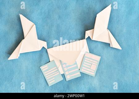 Due colombe origami di carta che trasportano una busta Letter. Ricevere e-mail come newsletter, sondaggio e invito. Foto Stock