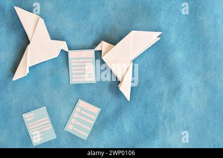 Due colombe origami di carta che trasportano una busta Letter. Ricevere e-mail come newsletter, sondaggio e invito. Foto Stock