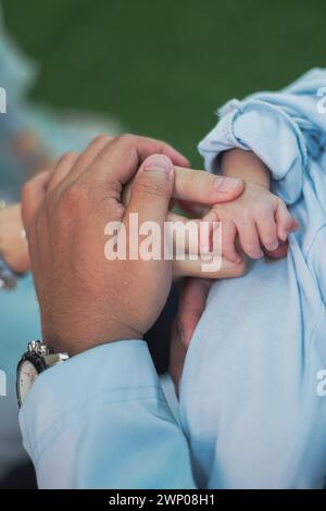 Un primo piano delle mani di un padre, di una madre e di un bambino che si tengono in braccio. una famiglia che significa protezione, calore, unione e amore. Foto Stock