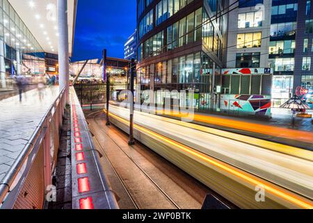 Foto a lunga esposizione di Manchester Piccadilly che mostra tram, auto e pedoni in movimento. Foto Stock