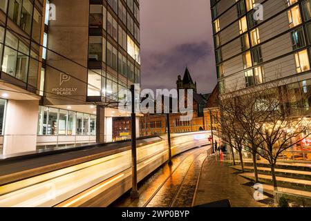 Foto a lunga esposizione di Manchester Piccadilly che mostra tram, auto e pedoni in movimento. Foto Stock