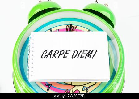 La frase latina Carpe Diem, una citazione di Orazio, significa cogliere il momento. In diretta nel presente riportato sul biglietto da visita della sveglia Foto Stock