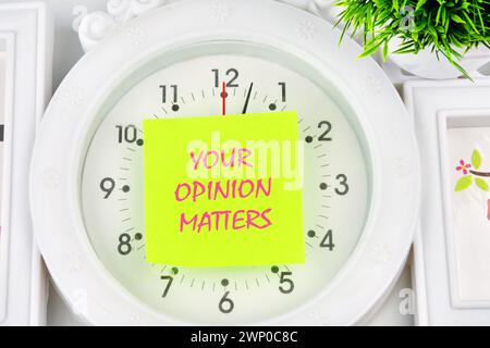 LA TUA OPINIONE CONTA una frase scritta sull'adesivo giallo sull'orologio Foto Stock