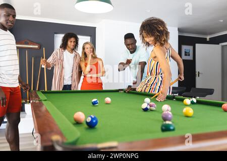 Gruppi diversi di amici si divertono a giocare a biliardo in un ambiente domestico Foto Stock