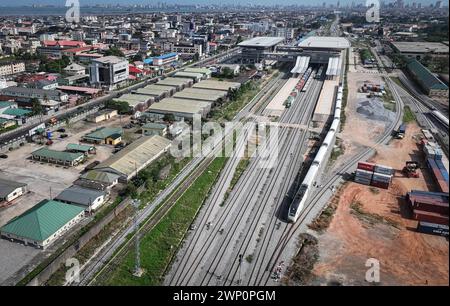 (240305) -- LAGOS, 5 marzo 2024 (Xinhua) -- una foto con un drone aereo scattata il 2 marzo 2024 mostra un treno passeggeri diretto a Ibadan in partenza dalla stazione ferroviaria Mobolaji Johnson della ferrovia Lagos-Ibadan a Lagos, Nigeria. Costruita dalla China Civil Engineering Construction Corporation (CCECC), la ferrovia Lagos-Ibadan collega il centro economico nigeriano Lagos e la città industriale sud-occidentale Ibadan. Aperto ufficialmente al traffico nel giugno 2021 con una linea principale lunga circa 157 chilometri e una diramazione lunga circa 7 chilometri, adotta i moderni standard ferroviari e ha una velocità progettata Foto Stock