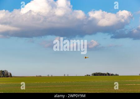 Un aeroplano applica sostanze chimiche a un campo. Aviazione agricola. Foto Stock