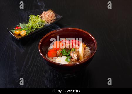 Bun CA, spaghetti di riso vietnamiti e pesce tritato alla griglia, cibo vietnamita isolato su sfondo da tavola in legno nero Foto Stock