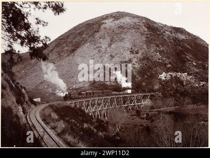 Treno a vapore che attraversa un ponte di legno di fronte a una grande collina. Locomotive di classe G su ciascuna estremità del treno. Ponte ferroviario, a sud di Picton. Nuova Zelanda circa 1900 Foto Stock
