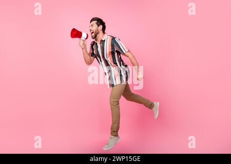 Foto a tutta lunghezza del corpo di un uomo maturo eccitato che urla il megafono promuovendo una grande vendita isolata su sfondo rosa pastello Foto Stock