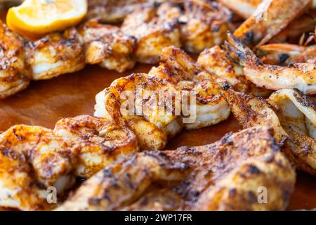 Gamberi grigliati su piatto di legno di pesce. Primo piano di tagliere di salumi con gamberi, pesce, calamari e polpo nel ristorante di pesce. Primo piano Foto Stock