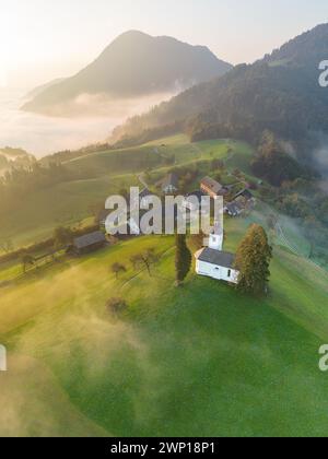 Chiesa di Sveti Tomaž in Slovenia in una mattina nebbiosa Foto Stock