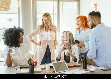 Team di colleghi che si riuniscono in ufficio mentre parlano di un nuovo progetto. Concetto di business. Foto Stock