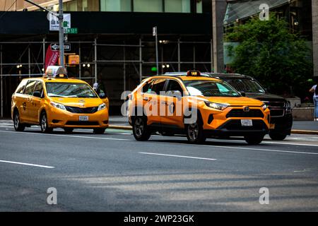 New York, USA; 4 giugno 2023: Due taxi gialli parcheggiati nel mezzo di Manhattan nella grande Mela, questo è il mezzo di trasporto tipico di New York ci Foto Stock