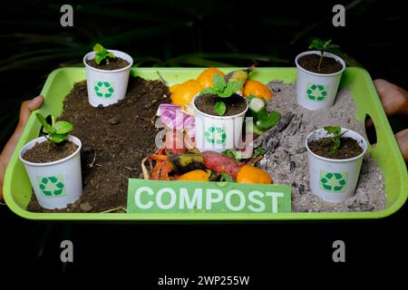 il terreno compostato ricicla i bicchieri di carta e le verdure di scarto Foto Stock