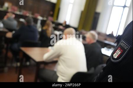 Amburgo, Germania. 5 marzo 2024. Gli imputati siedono con i loro avvocati in aula nell'edificio della giustizia penale all'inizio del processo per omicidio, amministrando segretamente il metadone. I tre imputati sono accusati di aver ucciso un uomo il 14 aprile 2023 amministrando segretamente il metadone e poi rubando i suoi oggetti di valore. Crediti: Marcus Brandt/dpa/Alamy Live News Foto Stock