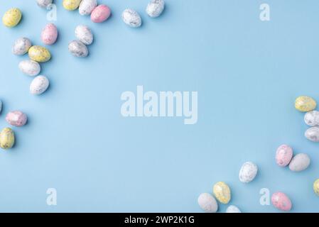 Sfondo natalizio di Pasqua. Uova di Pasqua multicolore su un tavolo blu. Scheda con spazio per il testo. Vista dall'alto. Foto Stock