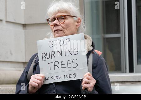 Londra, Regno Unito. 5 marzo 2024. Gli attivisti ambientali protestano al di fuori del Department for Energy Security and Net Zero (DESNZ) contro i piani governativi di fornire ulteriori sussidi pubblici alle centrali elettriche che bruciano alberi Drax, nello Yorkshire, e Lynemouth nel Northumberland. L’ex centrale a carbone di Drax, che già riceve ingenti sovvenzioni pubbliche, brucia pellet di legno importati, anche da alberi abbattuti nelle foreste primarie di vecchia crescita, ed è uno dei principali emettitori di CO2 e particolato (PM10) nel Regno Unito. I critici contestano anche la sua affermazione di essere una fonte di energia "rinnovabile". Foto Stock