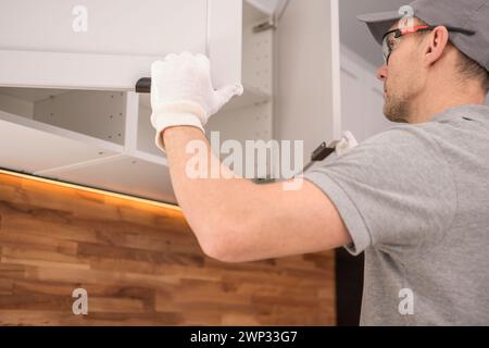 Armadietti professionali dei 40 anni che controllano gli accessori per mobili da cucina Foto Stock