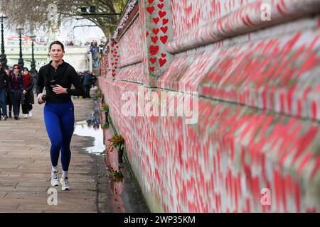 Londra, Regno Unito. 3 marzo 2024. Una donna fa jogging davanti al National Covid Memorial Wall a Westminster, Londra. Quattro anni fa, il 5 marzo 2024, una donna di 70 anni è stata confermata come la prima persona a morire di coronavirus nel Regno Unito. Da allora, oltre 237.110 persone sono morte per Covid-19. (Foto di Steve Taylor/SOPA Images/Sipa USA) credito: SIPA USA/Alamy Live News Foto Stock