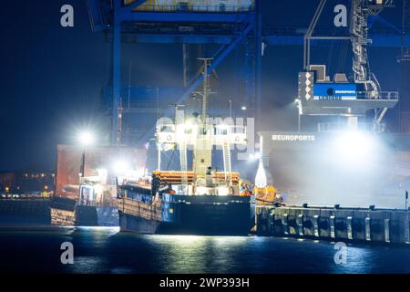 Rostock, Germania. 29 febbraio 2024. Due montagne russe sono caricate di merci sfuse al porto d'oltremare del porto di Rostock in tarda serata. L'Ufficio federale di statistica fornisce informazioni sulle attuali cifre relative alle esportazioni nel gennaio 2024. Crediti: Jens Büttner/dpa/Alamy Live News Foto Stock