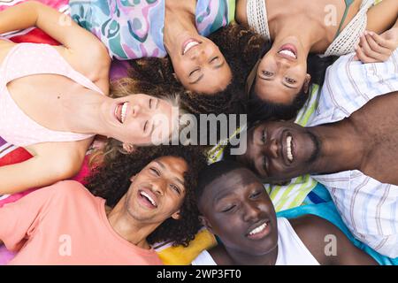 Un gruppo di giovani adulti in cerchio, sorridenti verso l'alto Foto Stock