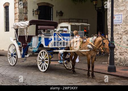 Carrozza dipinta trainata da cavalli in attesa di passeggeri nella vecchia città coloniale di Santo Domingo, Repubblica Dominicana. Patrimonio dell'umanità dell'UNESCO Foto Stock