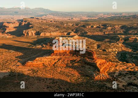 Vista aerea del monitor e del Merrimac Buttes al tramonto vicino a Moab, Utah, con le montagne innevate la Sal alle spalle. Foto Stock