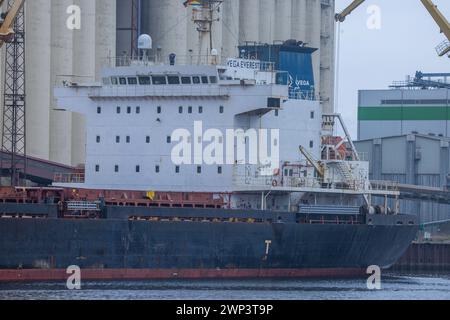 Rostock, Germania. 28 febbraio 2024. Navi da carico ormeggiate alla banchina di merci sfuse nel porto d'oltremare del porto di Rostock e in fase di carico. L'Ufficio federale di statistica fornisce informazioni sulle attuali cifre relative alle esportazioni nel gennaio 2024. Crediti: Jens Büttner/dpa/Alamy Live News Foto Stock