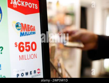 New York, Stati Uniti. 4 marzo 2024. Un cliente compra una lotteria mentre un display mostra il jackpot Mega Millions a 650 milioni di dollari al Rockefeller Center martedì 5 marzo 2024 a New York. Foto di John Angelillo/UPI credito: UPI/Alamy Live News Foto Stock