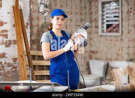 Lavoratore femminile che si posa in cantiere al coperto Foto Stock
