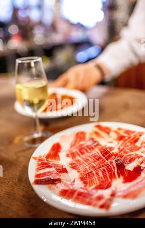 Una porzione di prosciutto iberico e fino sherry in un tradizionale bar sivigliano. Foto Stock