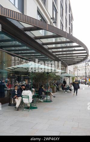 Le persone sedute ai tavoli del marciapiede prendono rinfreschi fuori dal Boutique and Cafe del Peninsula Hotel. Grosvenor Crescent Belgravia Londra, Inghilterra Foto Stock