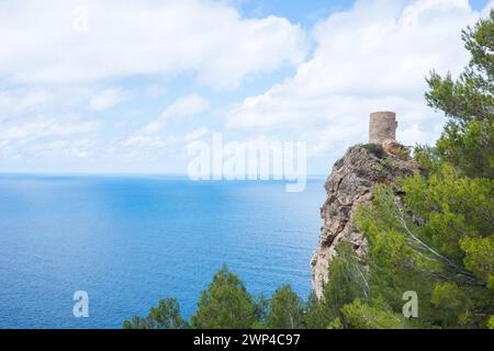 Torre des Verger, anche Torre del Verger, Torre de ses Animes, vecchia torre di guardia, torre di guardia su una roccia con tranquilla vista sul mare, alberi in primavera Foto Stock