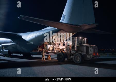 5 marzo 2024, luogo non divulgato, Stati Uniti: I caricatori e i portatori aerei dell'Air Force caricano un gruppo di finecorsa su un C-130J Super Hercules prima di caricare pallet di aiuti umanitari destinati a Gaza in un luogo non divulgato all'interno dell'area di responsabilità del comando centrale degli Stati Uniti, 5 marzo 2024. I soldati del comando centrale dell'Esercito degli Stati Uniti, specializzati nella fornitura di rifornimenti per l'airdrop, assicurarono che i paracadute fossero preparati per garantire che le forniture di cibo e acqua pallettizzate potessero essere sganciate in modo sicuro dall'aria per soddisfare le esigenze delle popolazioni civili a terra. (Immagine di credito: © U.S. Air Force/ZUMA Press W Foto Stock