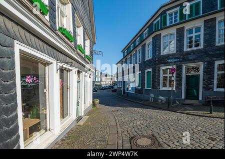 Una strada chiaramente acciottolata con vecchie case a graticcio e un cielo blu sopra, Graefrath, Solingen, Bergisches Land, Renania settentrionale-Vestfalia Foto Stock