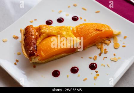 Fetta di crostata di crema alla pesca con mandorle affettate Foto Stock