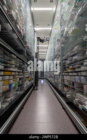 Le fotografie di un magazzino di farmacia e di una mano robot stanno organizzando e conservando farmaci in una farmacia. Foto Stock