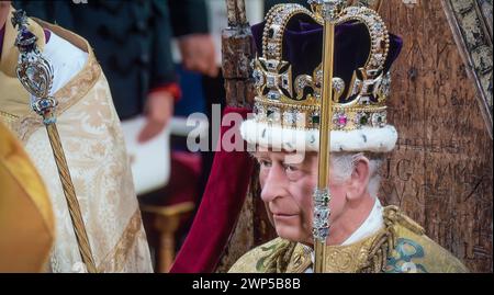 Re Carlo III incoronazione 6th maggio 2023 indossando la corona di Sant'Edoardo, tenendo lo sceptre del Sovrano con la Croce e lo sceptre con la dove, seduto nella sedia di incoronazione di 727 anni, che è stata usata durante l'incoronazione di 26 monarchi inglesi negli ultimi sette secoli. Qui fu ufficialmente dichiarato Re durante la sua incoronazione dall'Arcivescovo di Cantebury Justin Welby. Westminster Abbey Westminster Londra Regno Unito Foto Stock