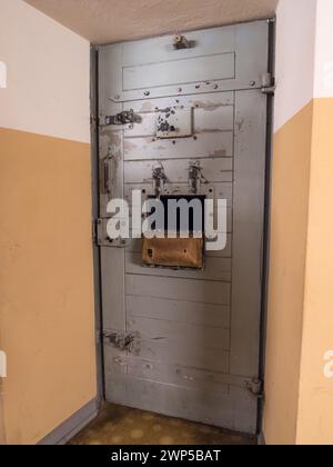 La porta, con imbottitura sulla porta del portello, di una cella imbottita nell'ala celle dell'ex prigione della Stasi della Guerra fredda Hohenschönhausen, Berlino. Foto Stock