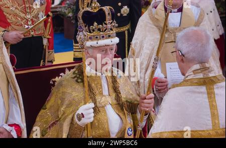 Re Carlo III incoronazione 6th maggio 2023 indossando la corona di Sant'Edoardo, tenendo lo sceptre del Sovrano con la Croce e lo sceptre con la dove, seduto nella sedia di incoronazione di 727 anni, che è stata usata durante l'incoronazione di 26 monarchi inglesi negli ultimi sette secoli. Qui fu ufficialmente dichiarato Re durante la sua incoronazione dall'Arcivescovo di Cantebury Justin Welby. Westminster Abbey Westminster Londra Regno Unito Foto Stock