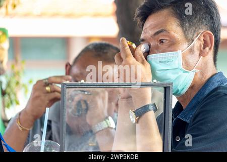 AYUTTHAYA, THAILANDIA, DEC 10 2023, gli uomini esaminano gioielli in una vendita di strada Foto Stock